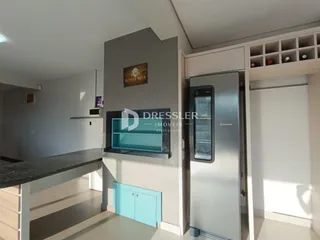 Ambiente de sala de estar e cozinha moderna em um imóvel no Brasil.
