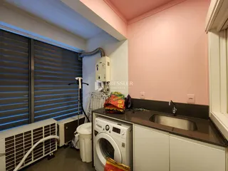 Foto de um ambiente interno com pia, máquina de lavar e vaso sanitário.