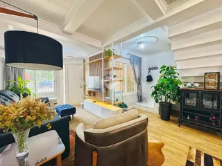 Sala de estar com piso de madeira clara e muita luz natural.