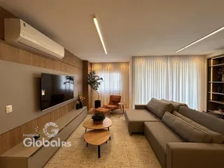Sala de estar moderna com sofá e televisão montada na parede.