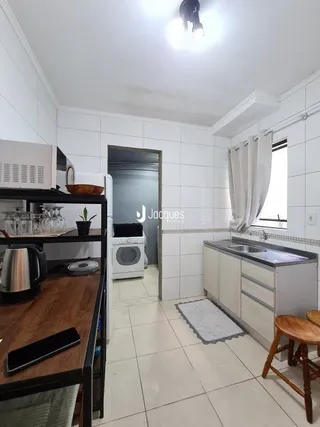 Vista de um corredor interno com piso de cerâmica branca.