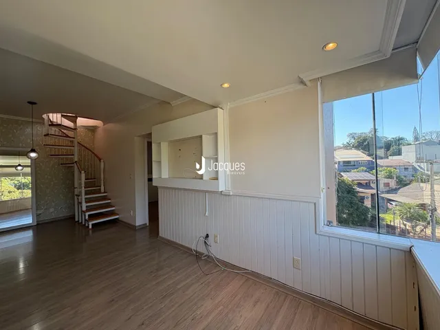 Sala de estar com piso de madeira e grande janela de vista para a rua.