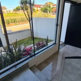 Vista externa de um jardim através de uma janela.