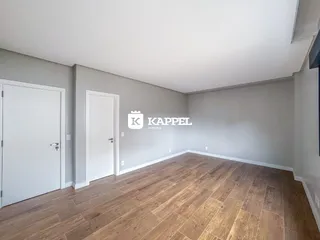 Foto de um ambiente interno com piso de madeira e portas brancas.