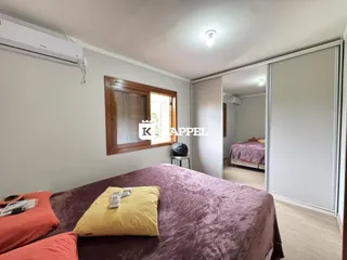 Quarto com cama grande e janela de madeira.