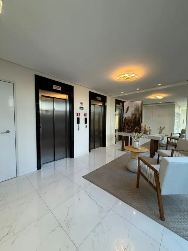 Foto de um corredor interno com piso de porcelanato branco e portas escuras.