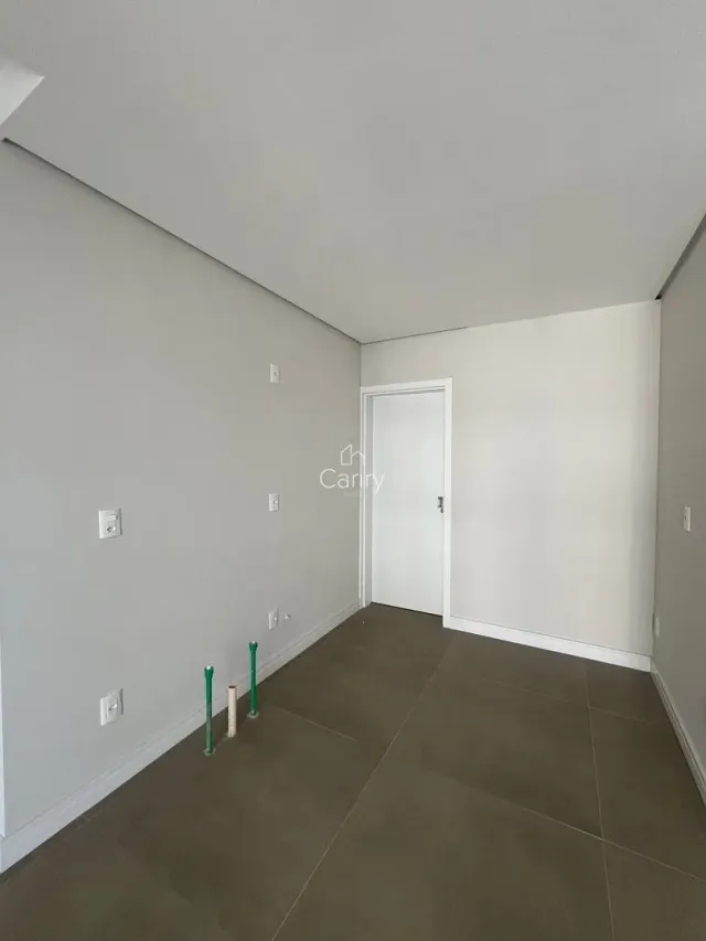 Corredor interno com paredes brancas e piso de cerâmica.