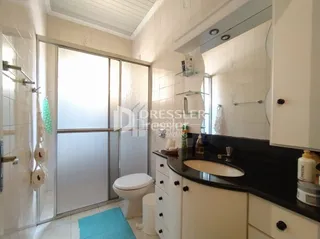 Foto de um banheiro com revestimento cerâmico e vaso sanitário branco.