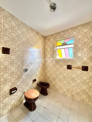 Foto de um banheiro com paredes de azulejo decorativo.