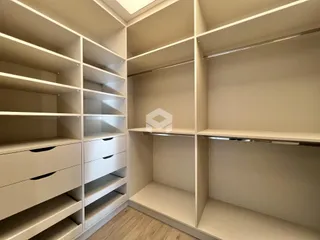 Interior com estantes e armários brancos em um ambiente.