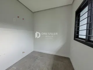 Foto de um cômodo interno com paredes brancas e piso cinza.