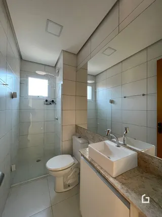 Um banheiro com revestimento branco e louças sanitárias.