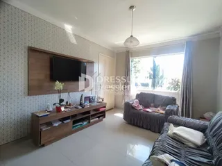 Uma sala de estar com sofá e painel de TV de madeira.