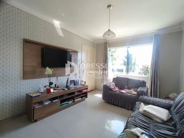 Uma sala de estar com sofá e painel de TV de madeira.