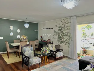 Sala de estar com mesa de jantar e cadeiras em ambiente interno.