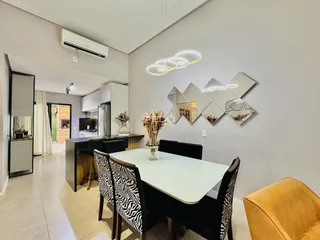 Uma sala de jantar com mesa e cadeiras em um ambiente claro.