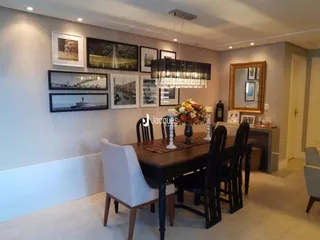 Ambiente interno de sala de jantar com mesa de madeira e espelhos.