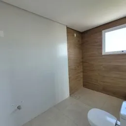 Foto de uma parede interna com revestimento de madeira clara.
