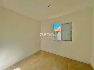 Vista interna de um cômodo com paredes brancas e piso de cerâmica.