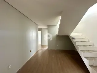 Hall de entrada com piso de madeira e escadaria.