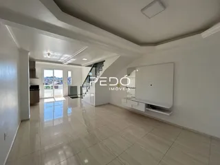 Interior de uma sala com piso de cerâmica e escadaria.