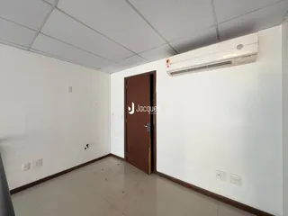 Ambiente interno de uma sala com paredes brancas e piso claro.