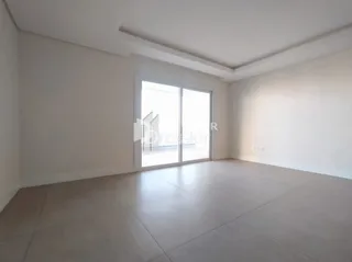 Ambiente interno de uma sala com paredes brancas e porta de vidro.