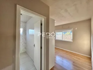 Vista de um corredor interno com porta branca em uma residência.