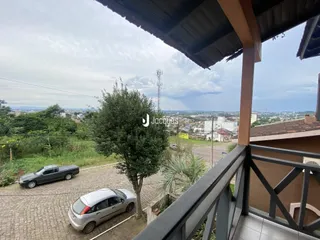 Vista da propriedade com paisagem e veículos no exterior.