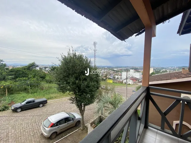 Vista da propriedade com paisagem e veículos no exterior.