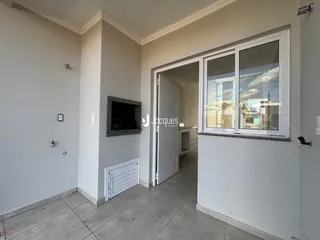 Interior de uma sala com paredes brancas e piso de cerâmica.