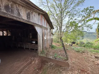 Fachada rústica de um celeiro de madeira no campo.