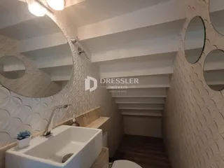 Vista de um banheiro com revestimento de cerâmica e bancada branca.