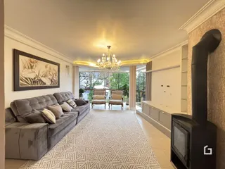 Sala de estar com sofá grande e decoração clássica.