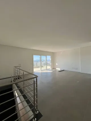 Vista ampla de um ambiente interno com grande janela e vista externa.