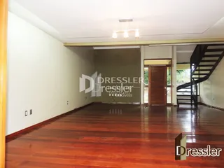Hall de madeira com piso polido e paredes brancas.