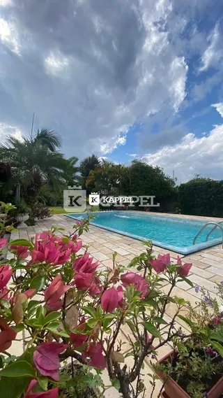 Foto externa mostrando uma piscina com vegetação exuberante.