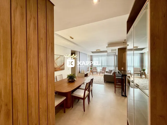 Uma sala de jantar com mesa de madeira e cadeiras.
