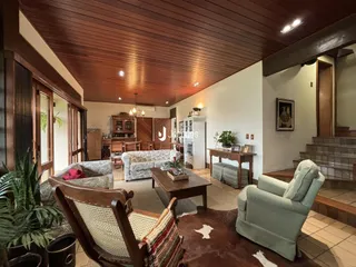 Sala de estar com piso de madeira e decoração rústica em Lajeado.