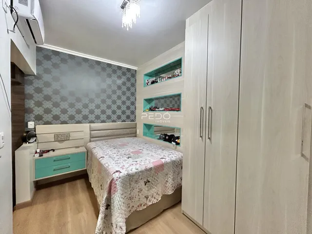 Quarto com cabeceira e armário em um apartamento.