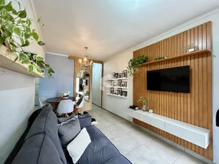 Sala de estar com sofá e painel de madeira na residência.