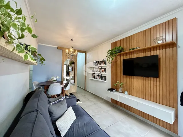 Sala de estar com sofá e painel de madeira na residência.