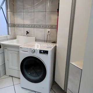Foto de um banheiro com pia e máquina de lavar roupa.