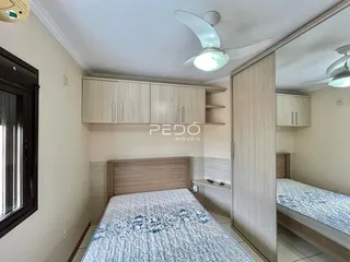 Quarto com armários e cama de madeira em um imóvel no Brasil.
