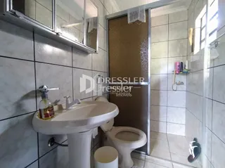 A foto mostra o interior de um banheiro com azulejos brancos.