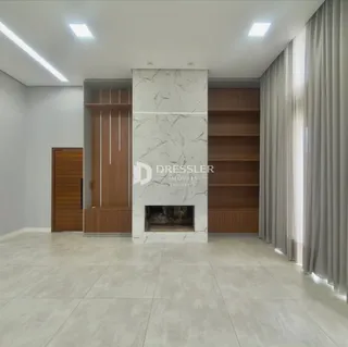 Ambiente interno com piso claro e lareira de mármore em uma residência.