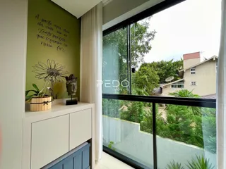 A sala apresenta uma parede verde com uma citação decorativa.
