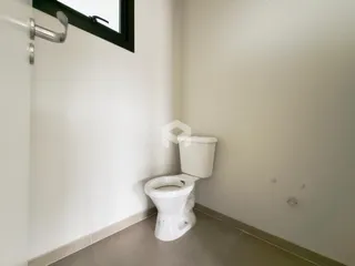 Foto de um ambiente interno de banheiro com paredes brancas.