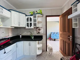 Cozinha com armários brancos e bancadas pretas.