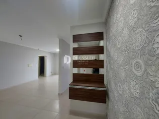 Hall da casa com paredes brancas e piso claro.